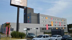 Een modern hotelgebouw met een opvallend reclamebord voor een radiostation.