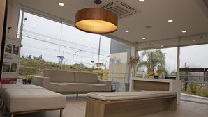 Een moderne hotelentree met een bank, een zitbank en een receptiebalie.