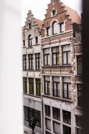 A multi-story building with a mix of brick and stone facades, featuring large windows and a traditional architectural style.
