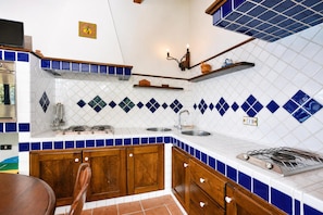 A kitchen with wooden cabinets, a stove, and a sink.