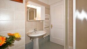A bathroom with a sink, mirror, and towel rack.