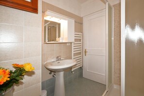 A bathroom with a sink, mirror, and towel rack. - Villetta Il Pino (Castiglione della Pescaia)