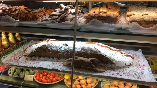 Eine Backvitrine mit verschiedenen Backwaren und frischem Obst.