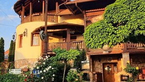 Ein traditionelles Gebäude mit einem Balkon, einem Steingewände und einem Schild, das ein freies Zimmer anzeigt.