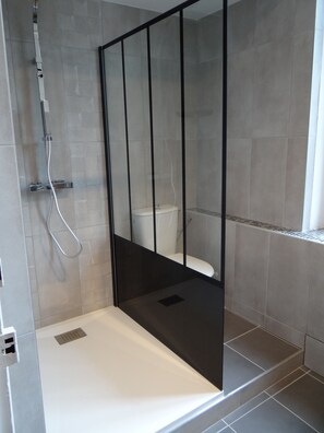 Een douche, handdoeken, zeep, toiletpapier