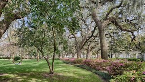 A park with large trees, a grassy path, and flowering shrubs. - Spacious Luxurious Townhome - 2 Blocks to Forsyth! (Savannah)