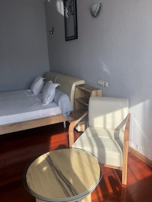 Una habitación con una cama, una silla y una pequeña mesa.