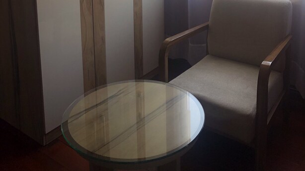 Une pièce comprenant une grande armoire, une table ronde en verre et une chaise.