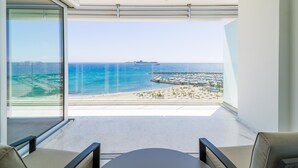 Een modern balkon met een helder uitzicht op zee en een jachthaven.