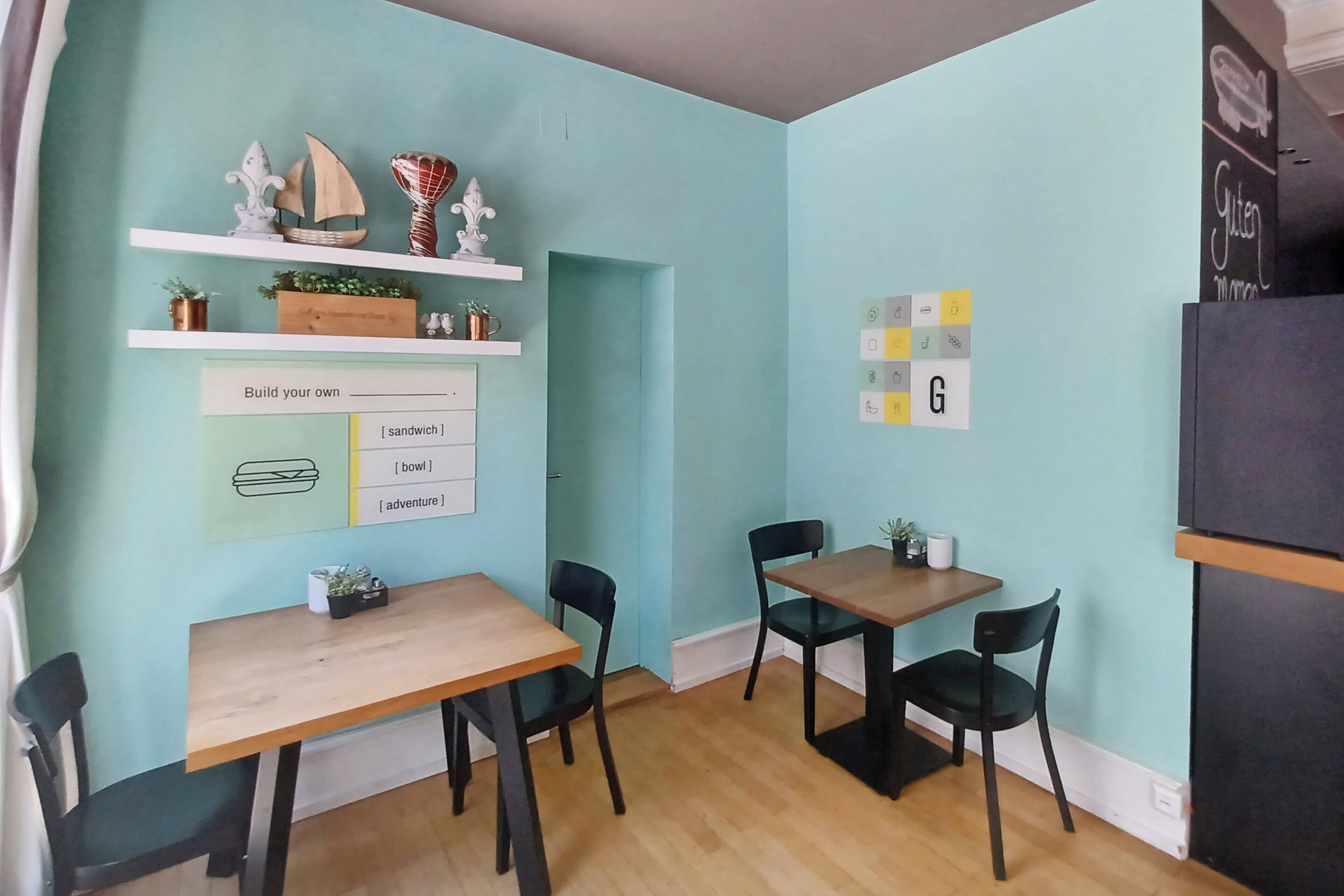 Une pièce aux murs de couleur turquoise, avec des meubles en bois et des objets décoratifs disposés sur des étagères.