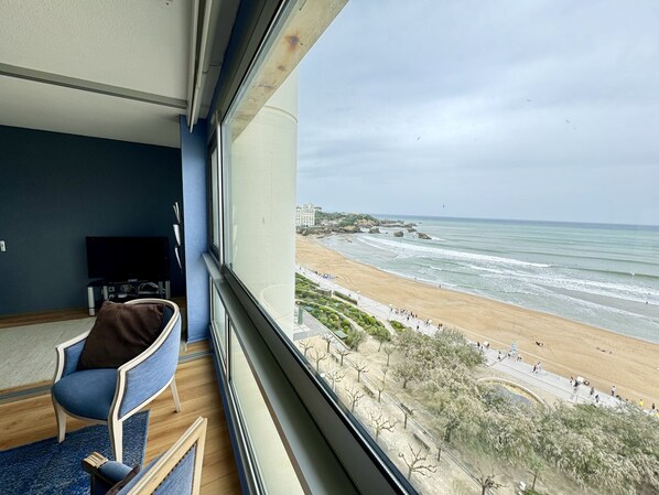 Una habitación con un amplio ventanal con vista a la playa.