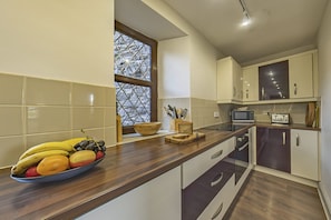 Enjoy cooking in this well-equipped kitchen with a large window offering a view of the outdoors.