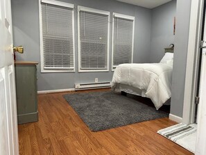 Cozy retreat with a comfortable bed, neutral decor, and natural light pouring in through the windows.