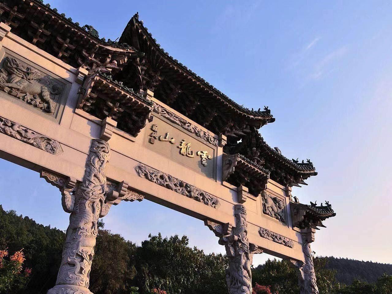 Een traditionele Chinese poort met ingewikkelde houtsnijwerken en een pannendak.