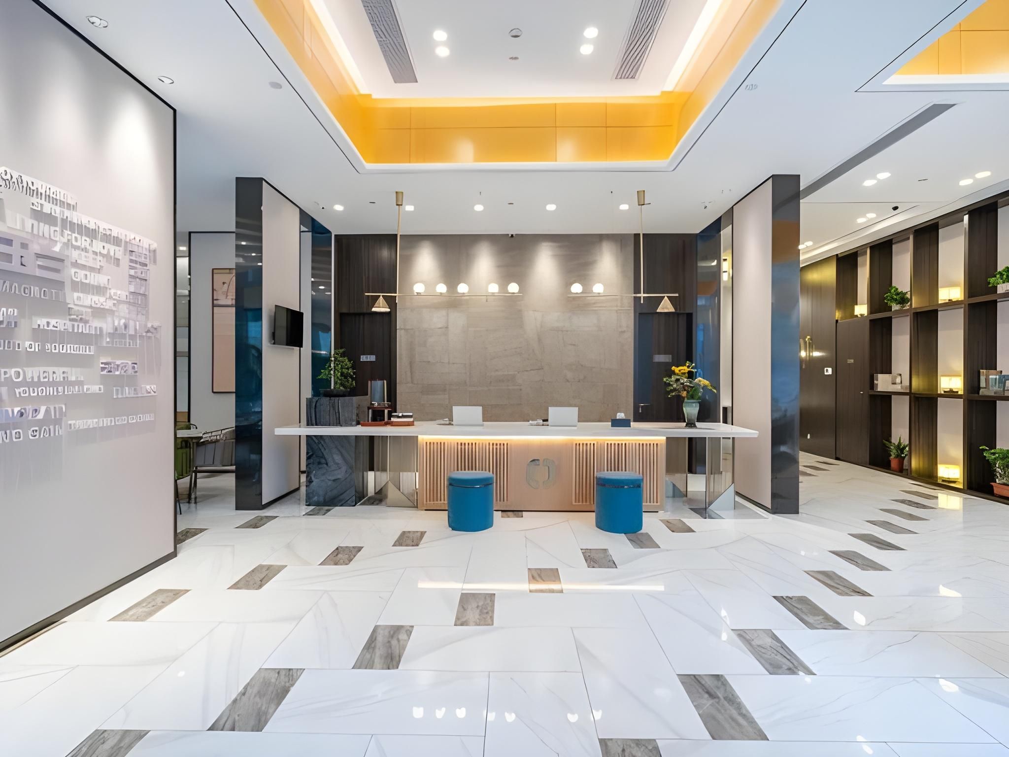 A modern reception area with a reception desk, seating, and a digital display wall.
