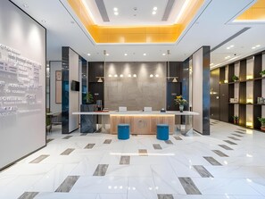 A modern reception area with a reception desk, seating, and a digital display wall. - Magnotel Hotel (Xuzhou Suning Plaza) (Xuzhou)