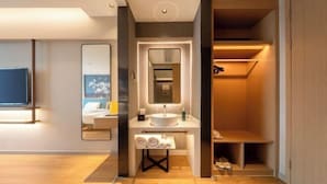 A modern bathroom with a vanity, sink, and mirror. There is a towel rack and a shelf with toiletries. - Magnotel Hotel (Xuzhou Suning Plaza) (Xuzhou)