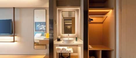 A modern bathroom with a vanity, sink, and mirror. There is a towel rack and a shelf with toiletries.