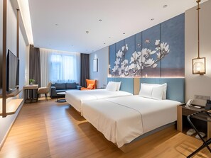 A hotel room with two beds, a seating area with a sofa and chairs, a TV, and a large floral artwork on the wall. - Magnotel Hotel (Xuzhou Suning Plaza) (Xuzhou)