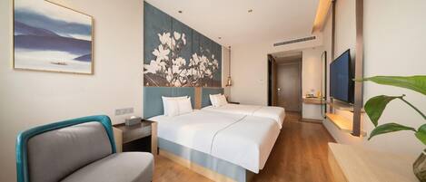 A hotel room with a bed, a desk, a chair, a TV, and a painting on the wall.