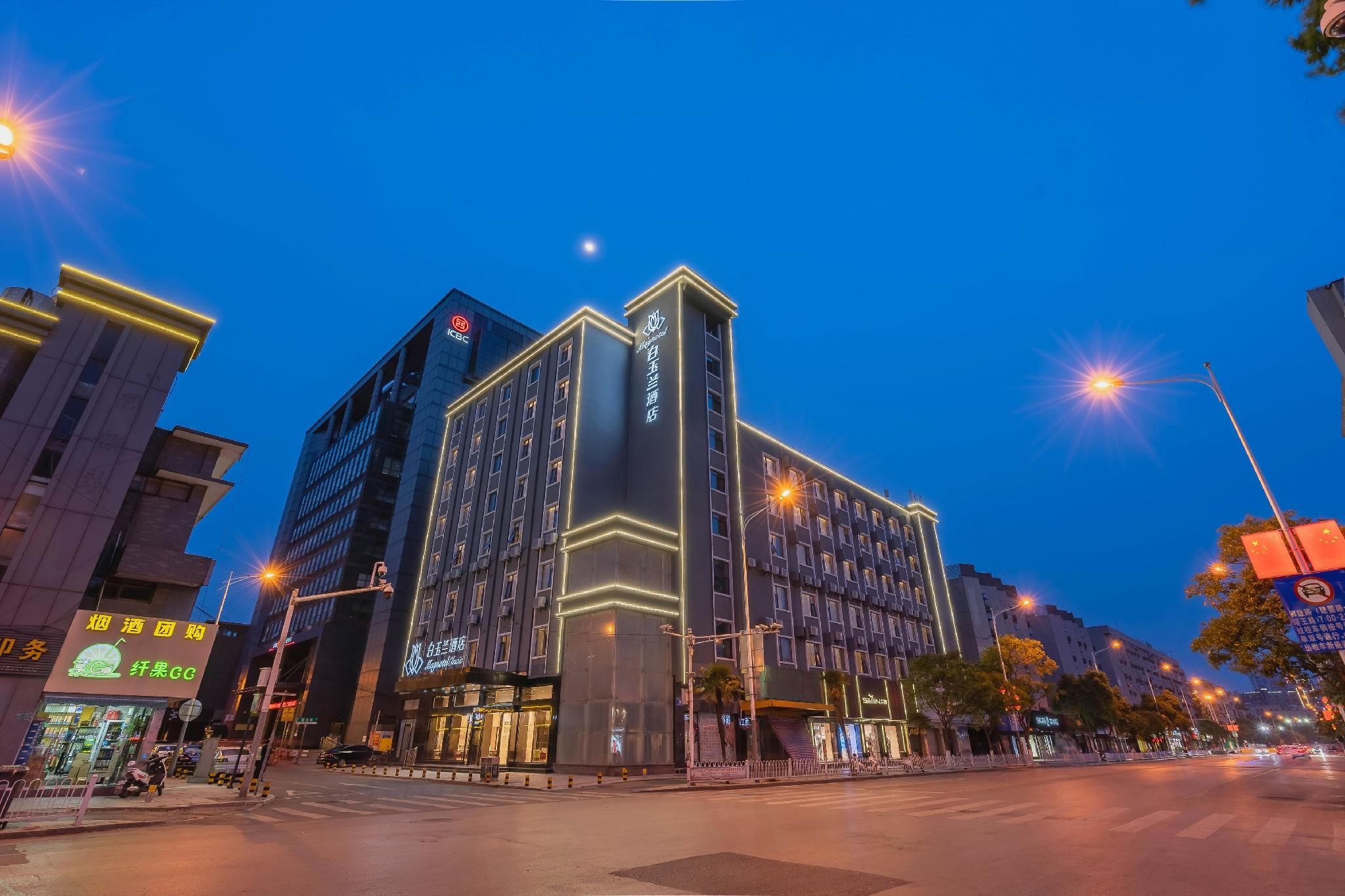 A multi-story hotel with illuminated signage, a prominent entrance, and a street view with surrounding buildings.