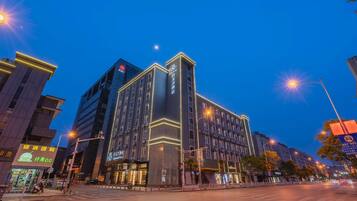 A multi-story hotel with illuminated signage, a prominent entrance, and a street view with surrounding buildings.
