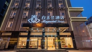 A hotel entrance with a sign reading "Magnotel Classic" and a logo above it. - Magnotel Hotel (Xuzhou Suning Plaza) (Xuzhou)