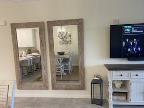 Una sala de estar moderna con un televisor mostrando 'POP HITS' y 'BTS Dynamite (Single) (2020)'.