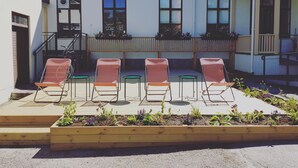 A building with a balcony, wooden steps, and a row of red chairs. - Prästgården Hotell & Bryggeri (Soderhamn)