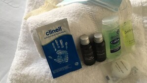 A white towel with a face mask, a Clinell hand wipe, and three bottles of Carex products. - Townhouse @ Victoria Road Stoke (Stoke-on-Trent)