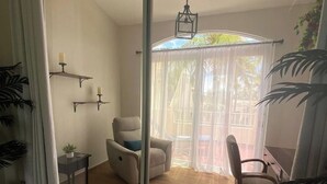 A room with a sliding glass door leading to an outdoor area with a chair and a table. - Romantic Penthouse with Roof Terrace (Humacao)