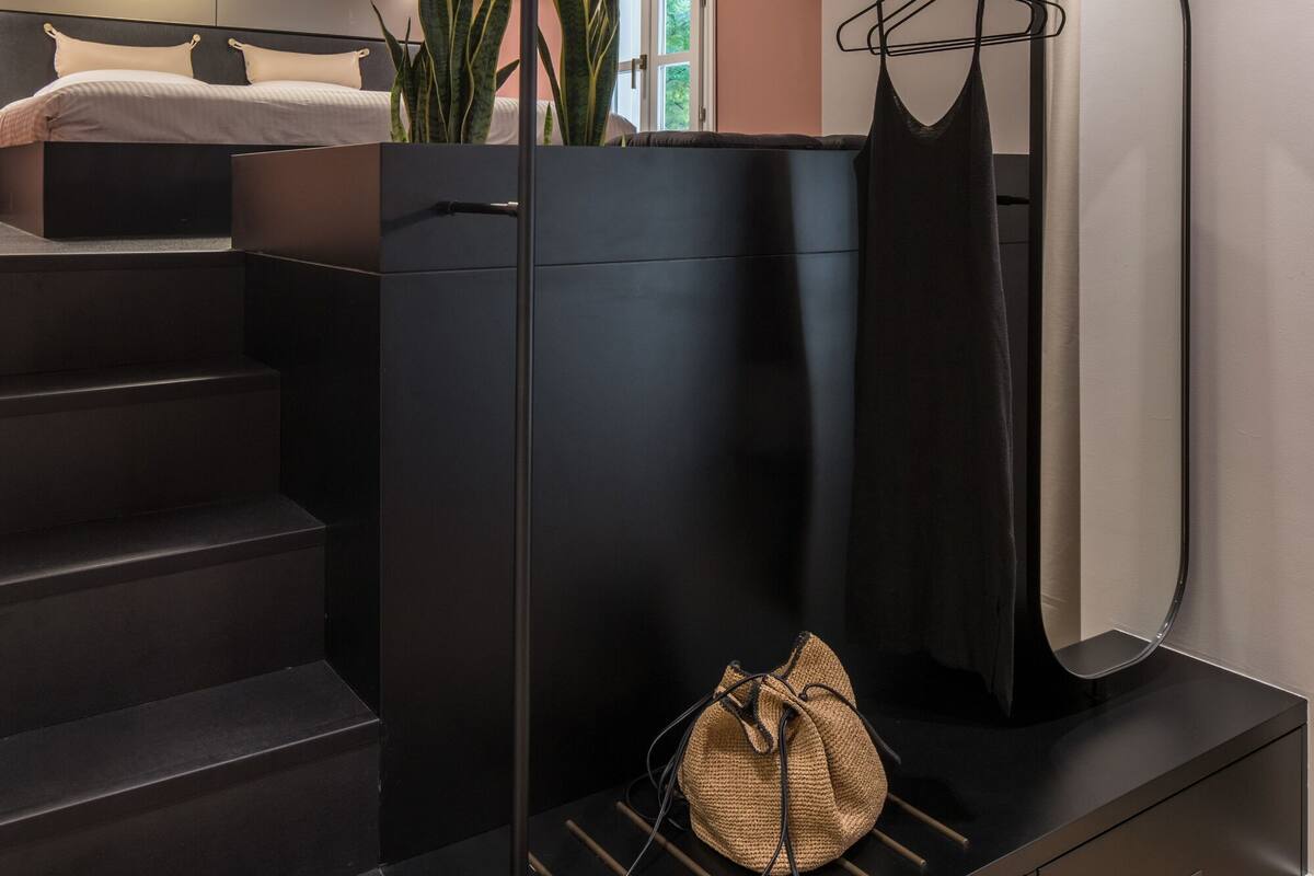 Una habitación moderna con una litera, un escritorio pequeño y una planta.