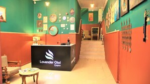 Un espace d’accueil avec un comptoir noir où figure le logo « Lavender Otel Çeşme ».