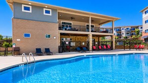 A swimming pool with lounge chairs and a covered patio area.