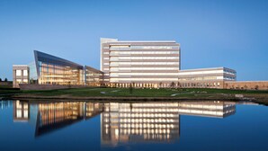 A modern building with a reflective pool in front.