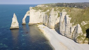 Paisatge costaner amb penya-segats blancs i una platja sorrenca.