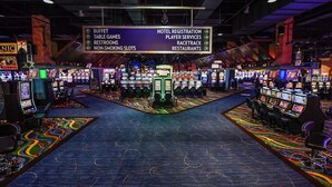 A casino with a sign listing amenities including buffet, table games, restrooms, non-smoking slots, hotel registration, player services, racetrack, and restaurants. - The McLure Hotel and Conference Center (Wheeling)