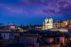 A historic building with two prominent towers, surrounded by other buildings and a clear sky. - Hotel Homs (Rome)
