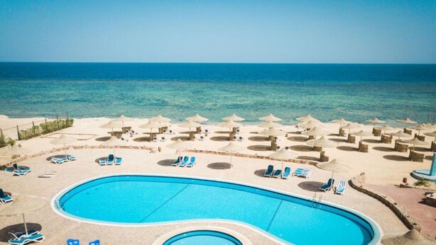 A pool area with lounge chairs and umbrellas, overlooking a beach and the sea. - Silver Beach Boutique Hotel (El Quseir)