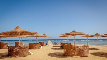 Playa privada, playa de arena blanca, camastros y sombrillas