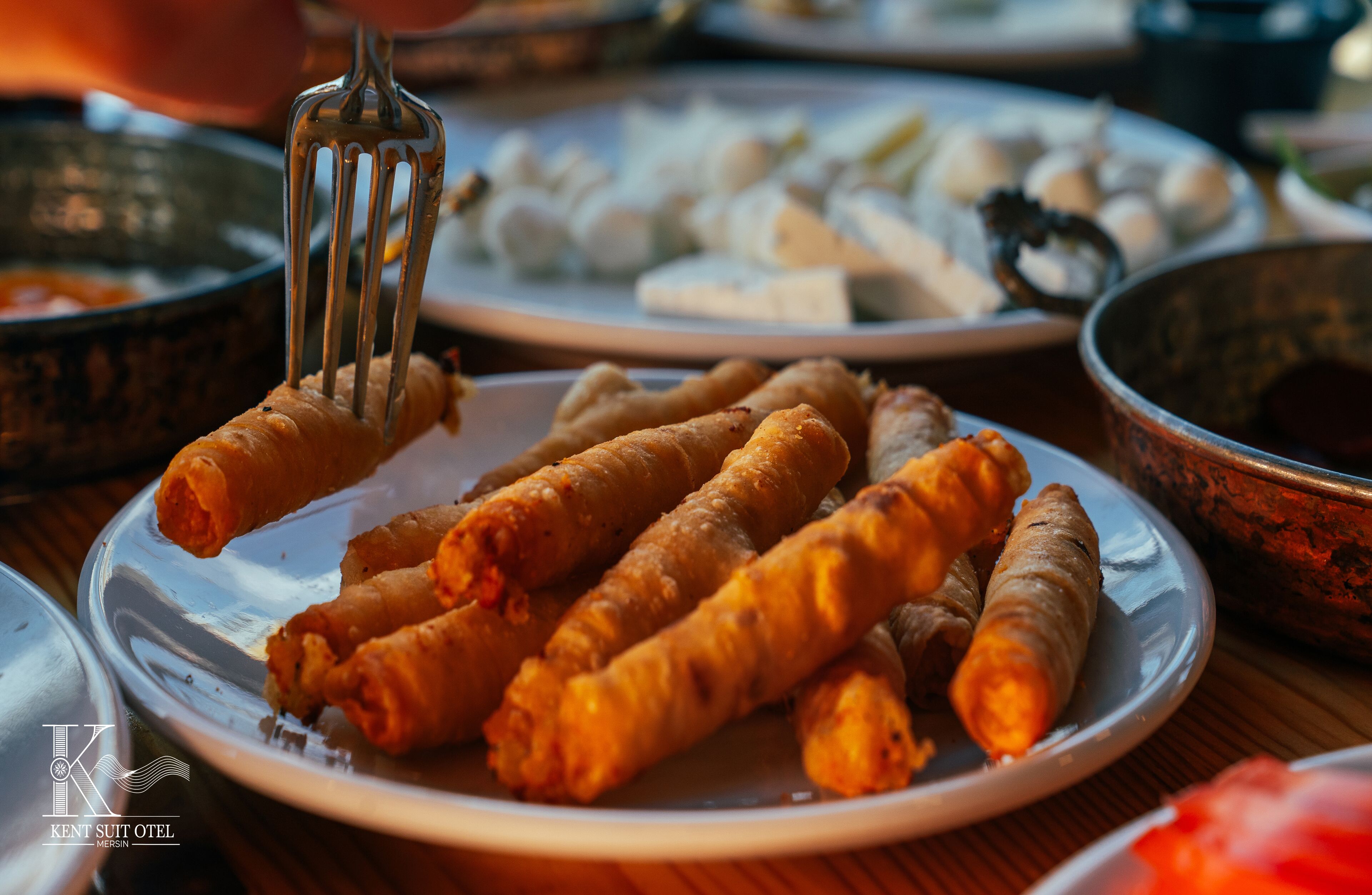 A plate of fried spring rolls with a fork.