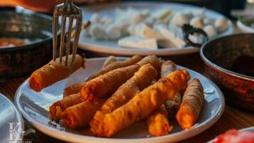 A plate of fried spring rolls with a fork.