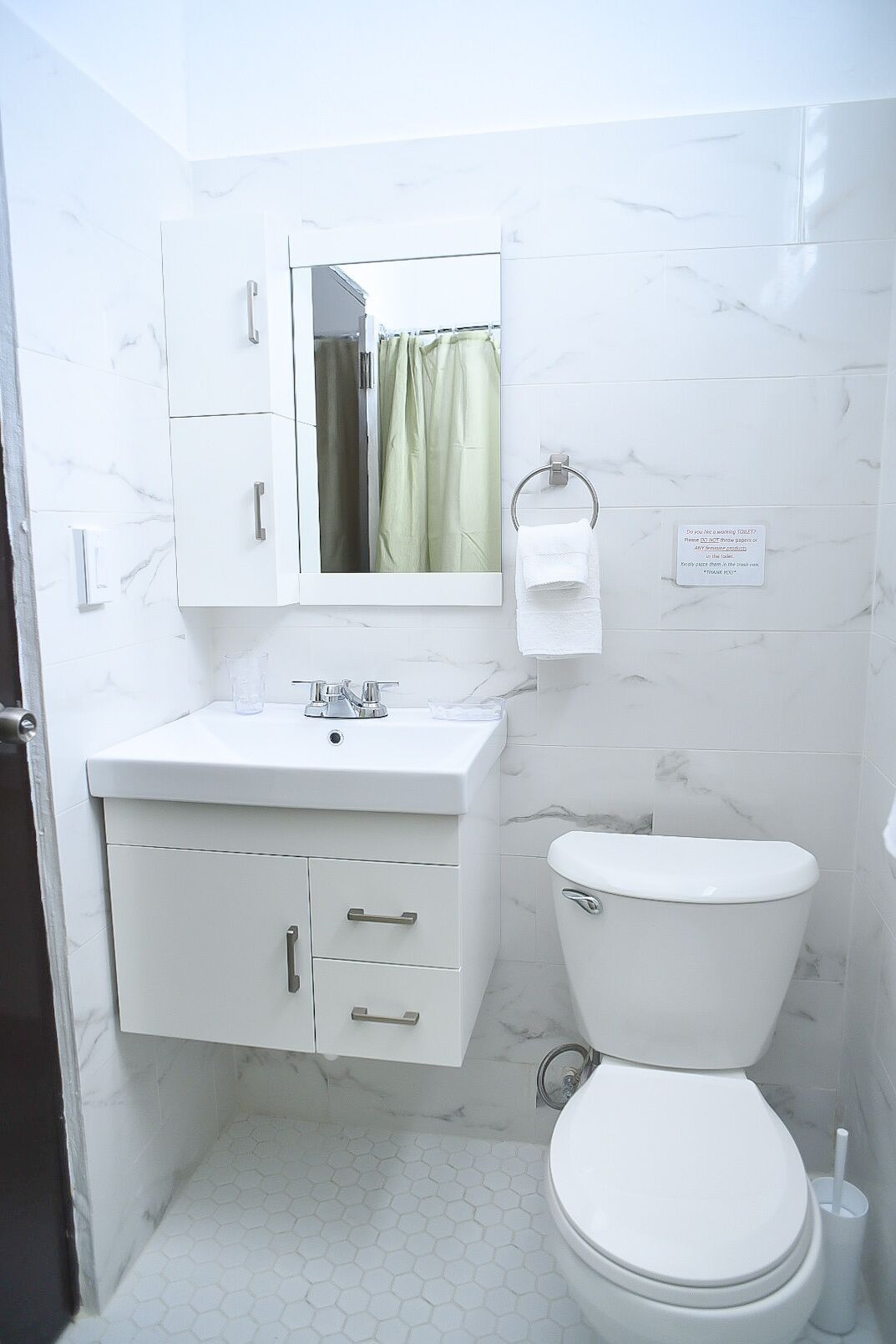 Ein Badezimmer mit Waschbecken, Spiegel und Toilette.
