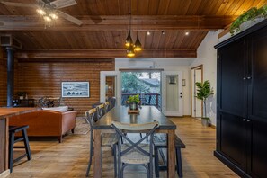 A wooden interior with a dining table, chairs, and a black cabinet. - Sonoma Wine Country Luxury Log Cabin (Sonoma)