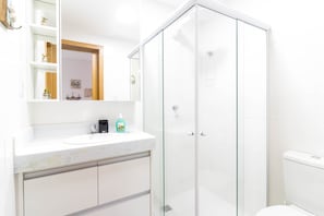 A modern bathroom with a glass shower enclosure, a white sink, and a toilet. - GB37 Excelente Apt 2 Suítes em Guarajuba (Camaçari)