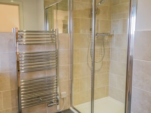 A glass-enclosed shower with a chrome towel rack and a handheld showerhead. - Coppa Hill Barn (Carnforth)
