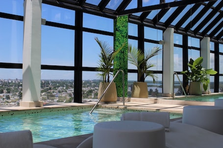 Una piscina techada, sillones reclinables de piscina