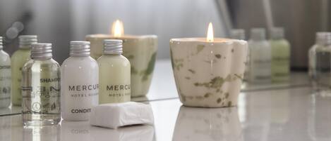 A bathroom with toiletries, candles, and a mirror.