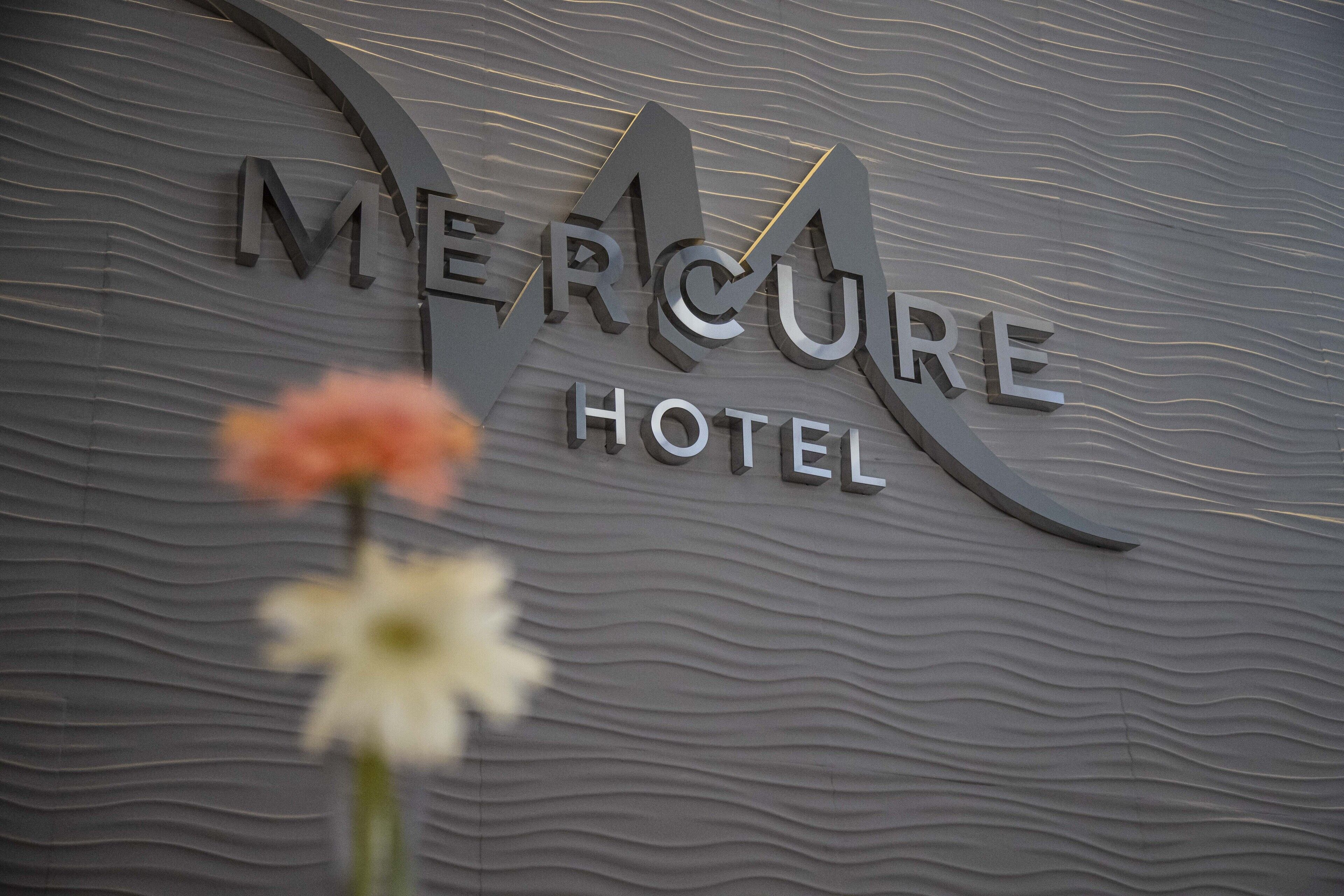 A sign for Mercure Hotel with a wavy texture background.