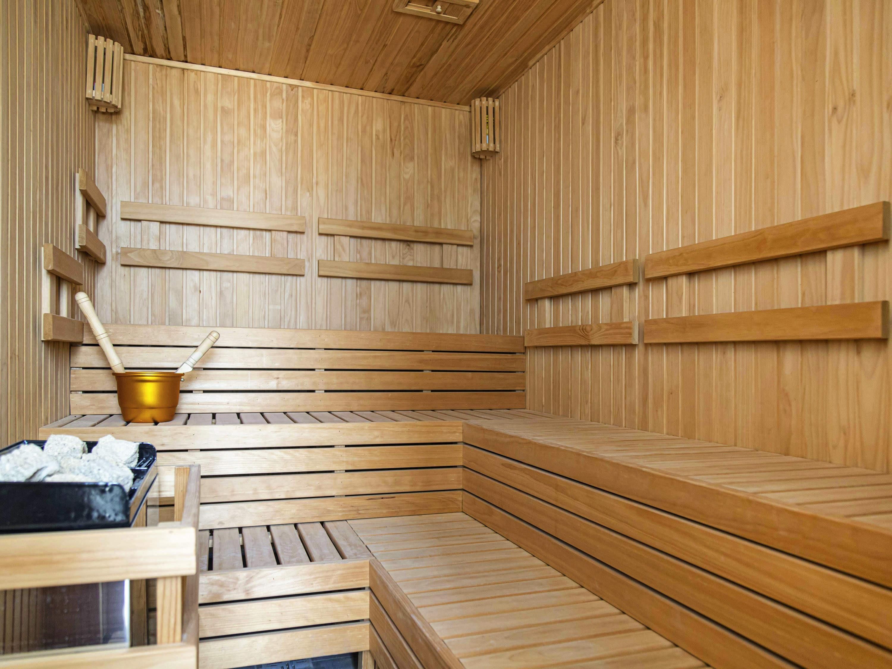 Una sauna de madera con bancos y un cubo.